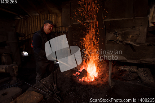 Image of young traditional Blacksmith working with open fire