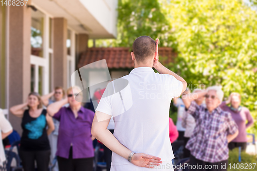 Image of trainer training motivated active healthy senior people