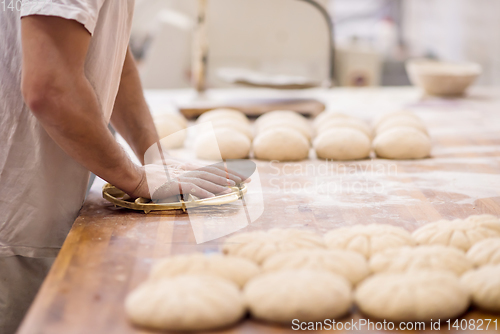 Image of bakery worker preparing the dough