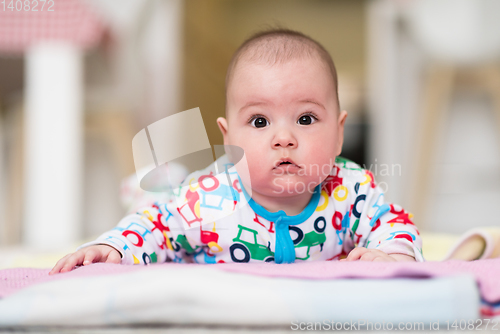 Image of newborn baby boy playing on the floor