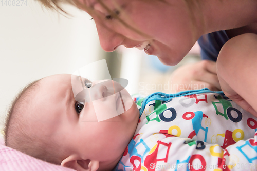 Image of young mother kissing her cute little baby