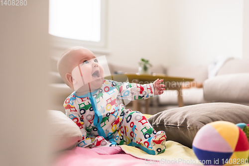 Image of newborn baby boy sitting on colorful blankets