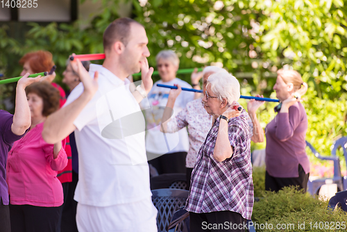 Image of trainer training motivated active healthy senior people