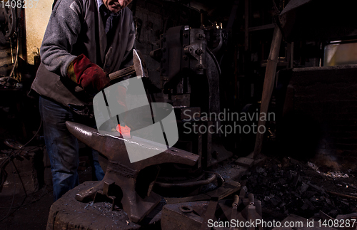 Image of blacksmith manually forging the molten metal