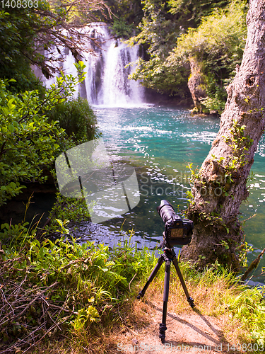 Image of profesional DSLR camera on a tripod at beautiful waterfall