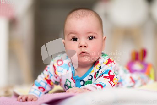 Image of newborn baby boy playing on the floor