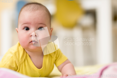 Image of newborn baby boy playing on the floor