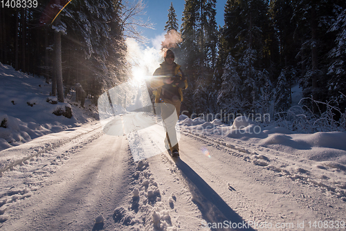 Image of young photographer walking on snowy country road