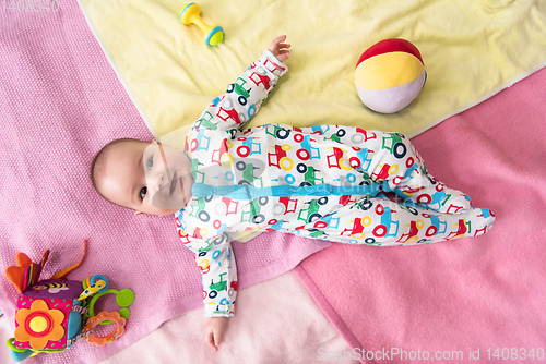 Image of top view of newborn baby boy lying on colorful blankets