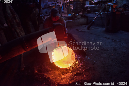 Image of blacksmith workers using mechanical hammer at workshop