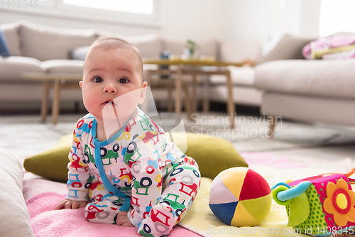 Image of newborn baby boy sitting on colorful blankets