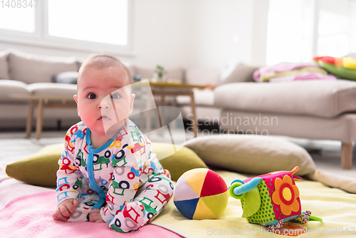 Image of newborn baby boy sitting on colorful blankets