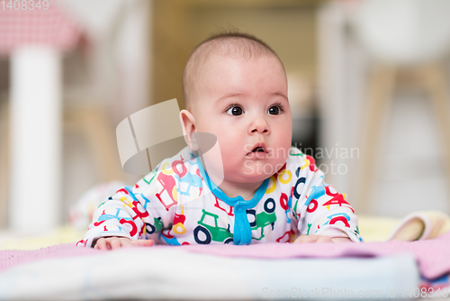 Image of newborn baby boy playing on the floor