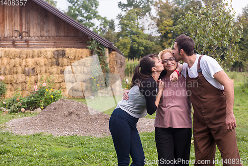 Image of grandmother being kissed by her lovely adult grandchildren