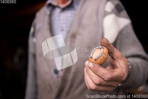 Image of A blacksmith worker showing handmade products ready for sale