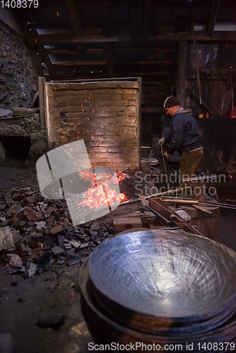 Image of young traditional Blacksmith working with open fire