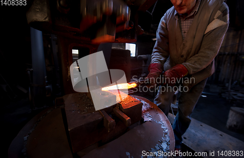 Image of blacksmith manually forging the molten metal