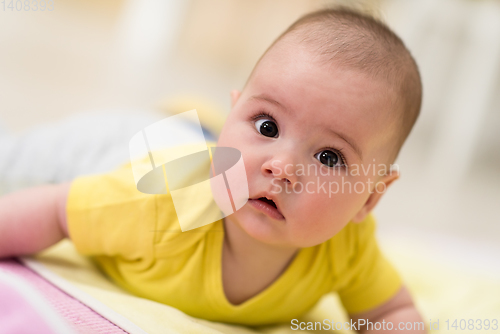 Image of newborn baby boy playing on the floor