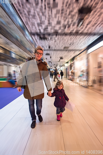 Image of young mother and her little pretty daughter shopping together