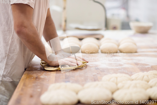 Image of bakery worker preparing the dough