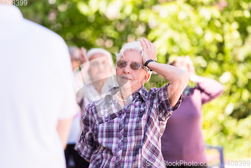 Image of senior woman exercising with friends