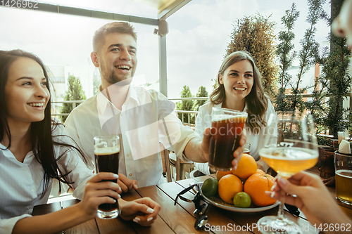 Image of Young group of friends drinking beer and celebrating together