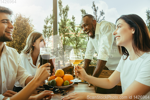 Image of Young group of friends drinking beer and celebrating together
