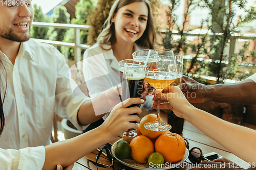 Image of Young group of friends drinking beer and celebrating together