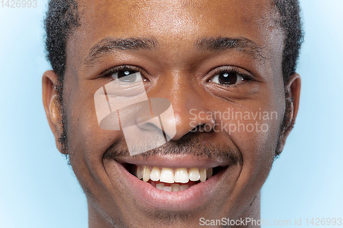 Image of Close up portrait of young man on blue background.