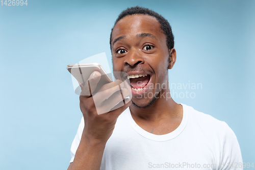 Image of Half-length close up portrait of young man on blue background.