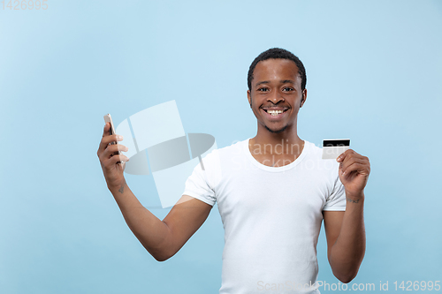 Image of Half-length close up portrait of young man on blue background.