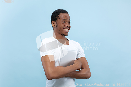 Image of Half-length close up portrait of young man on blue background.