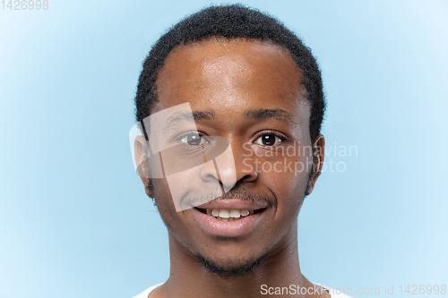 Image of Close up portrait of young man on blue background.