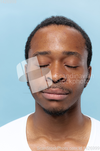 Image of Close up portrait of young man on blue background.