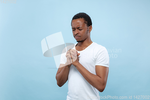 Image of Half-length close up portrait of young man on blue background.