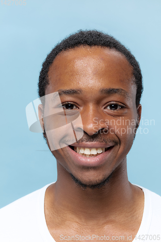 Image of Close up portrait of young man on blue background.