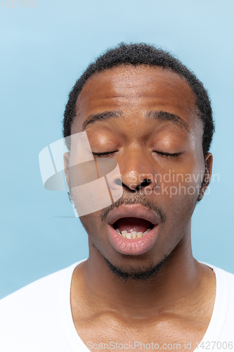 Image of Close up portrait of young man on blue background.