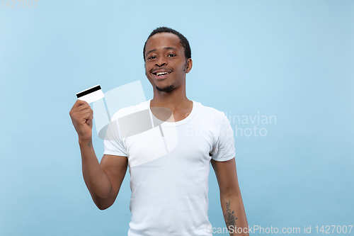 Image of Half-length close up portrait of young man on blue background.