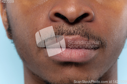 Image of Close up portrait of young man on blue background.