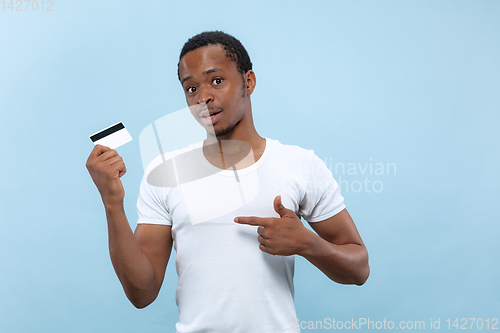 Image of Half-length close up portrait of young man on blue background.