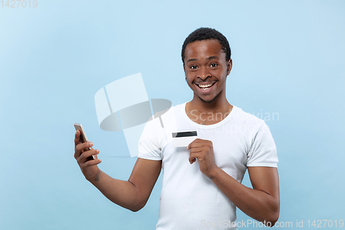 Image of Half-length close up portrait of young man on blue background.