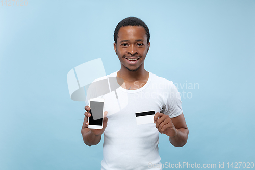 Image of Half-length close up portrait of young man on blue background.