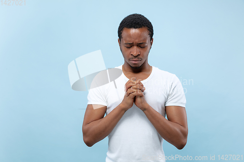 Image of Half-length close up portrait of young man on blue background.