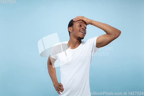 Image of Half-length close up portrait of young man on blue background.