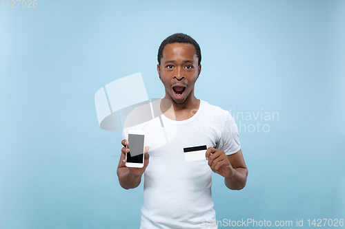 Image of Half-length close up portrait of young man on blue background.