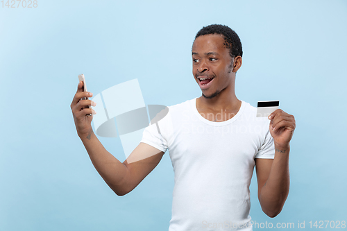 Image of Half-length close up portrait of young man on blue background.