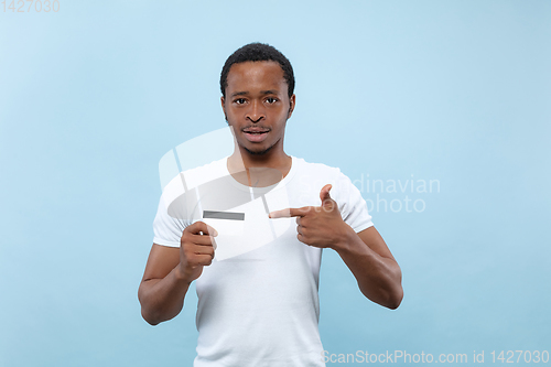 Image of Half-length close up portrait of young man on blue background.