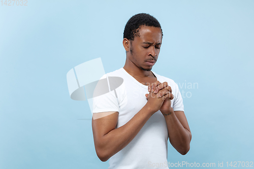 Image of Half-length close up portrait of young man on blue background.