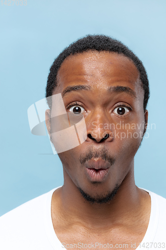 Image of Close up portrait of young man on blue background.