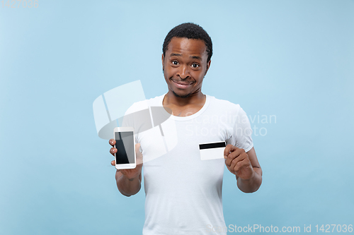 Image of Half-length close up portrait of young man on blue background.